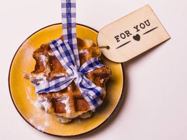 Tekstil ile Belçika Waffle hizmet üzerinde sarı plaka teyp, yukarıdan görüntüleyin. Kavramsal metin sizin için gösterilen