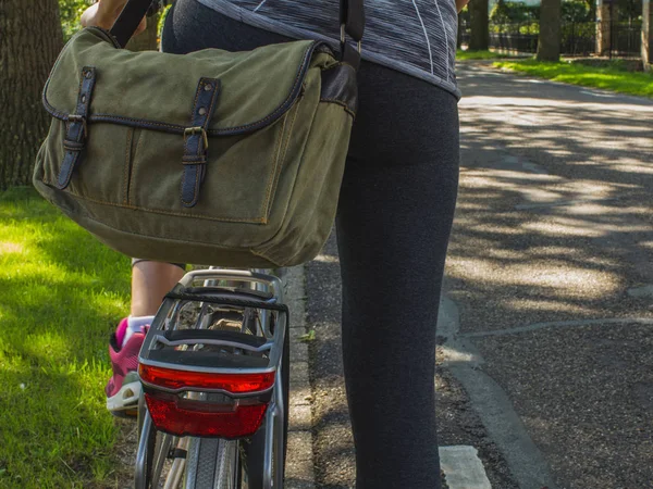 Sporty student on the bike with a school bag on a country road.