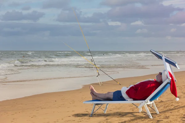 Noel Baba beach yatakta uyuyor. Noel Balık tutma.