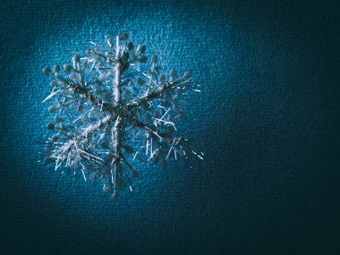 Mavi dokulu kağıt arka plan dekoratif bir kar tanesi ile.