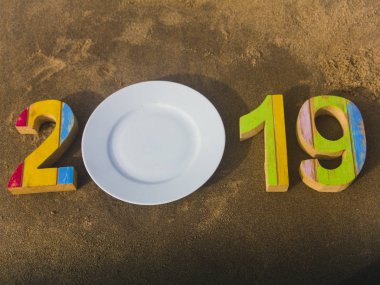 2018 yeni yıl kavramı. Ahşap beyaz tabak op kum arka plan sayılarla.