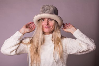 Eller yukarı, ile şapkalı güzel gülümseyen bayan arıyorum kamera, moda güzellik modeli, pastel leylak arka plan, yumuşak renkler