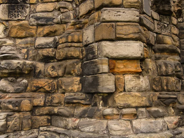 Textured old strong stone wall. Fragment of architectural buildings in Scotland, public places, uk.