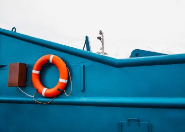 Kırmızı lifebuoy mavi feribota metal yüzeyde asılı.