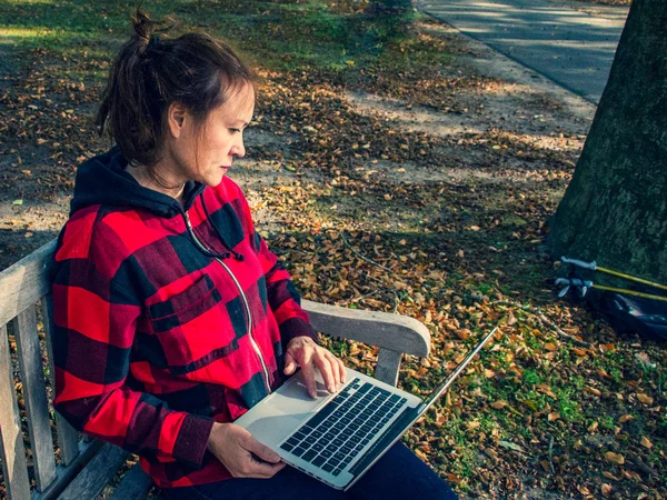 Journée ensoleillée d'automne dans le parc. Jeune femme sportive à la recherche d'inf — Photo