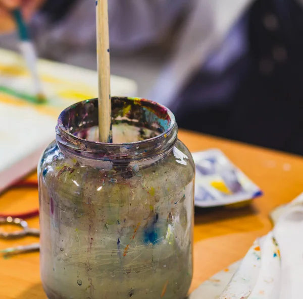 Close-up vuile glazen pot met een kwast op de tafel in Stud — Stockfoto