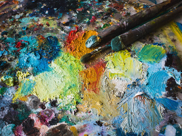 Mixing oil paints on palette with various colors, top view.