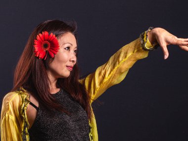 Uzun saçları kırmızı çiçek li zarif Asyalı kadın.