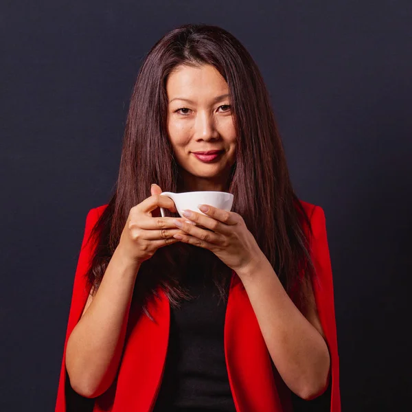 長い髪を持つエレガントなかわいいアジアの女性は、hでコーヒーのカップを保持します — ストック写真