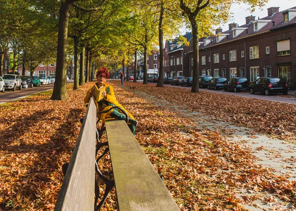 Humor de outono na cidade. bela ásia mulher sentado no um benc — Fotografia de Stock