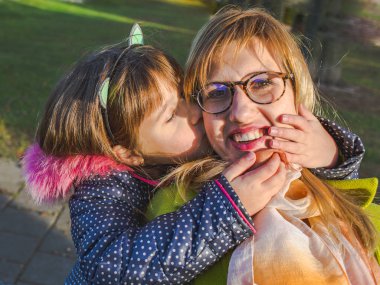 Mutlu genç anne ve kız birlikte eğleniyor. Komik aile anne.
