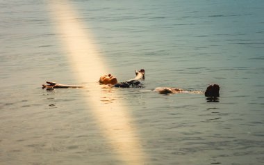 Yaşlı bir kadın rahatlar, deniz suyunda kaçmasına izin verir. Doğada güzel, sağlıklı bir hayat..