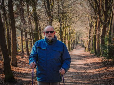 Aktif orta yaşlı bir adam sonbahar ormanlarında yürüyor, bakış açısı....