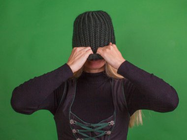 Bir kadın örgü bir şapkayla yüzünü kapatıyor. Tecrit