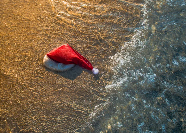 Islak Noel Baba Şapkası Deniz Suyunda Bir Kıyıda Yatmak Metin — Stok fotoğraf