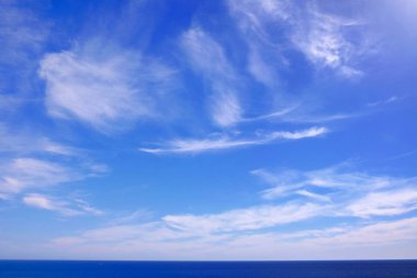 Beyaz bulutlarla deniz ve mavi gökyüzüne bak.