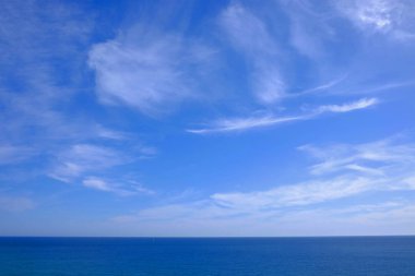 Beyaz bulutlarla deniz ve mavi gökyüzüne bak.