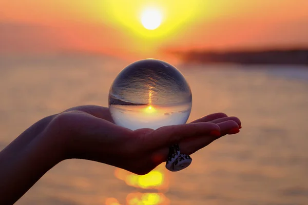 Bola de cristal en la palma con un reflejo invertido de los soles — Foto de Stock