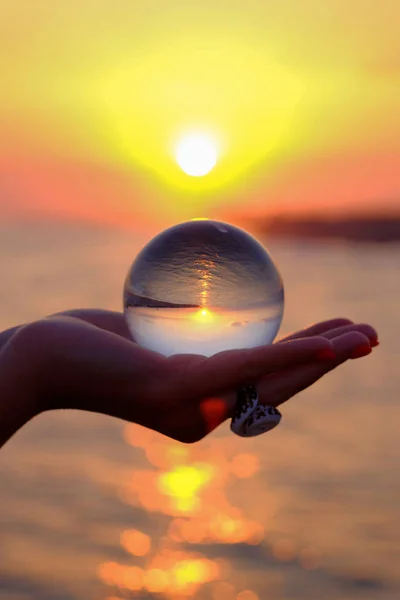 Esfera de vidrio en la palma con un reflejo invertido de los soles — Foto de Stock