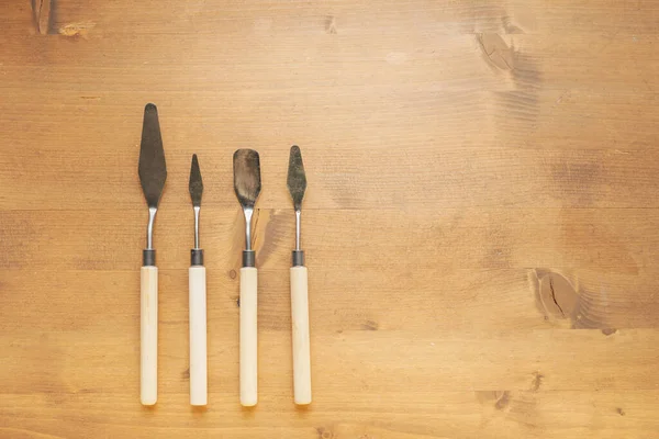 Kil ve plastikten maket yapmak için tahta arka planda fotokopi alanı olan bir spatula. Araçlar kümesi.