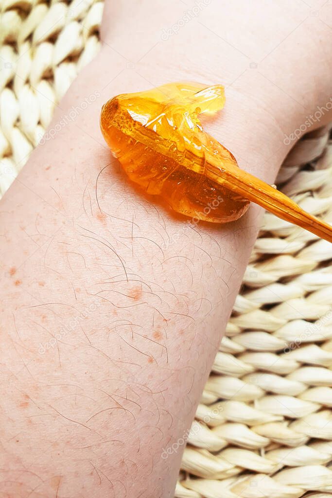 Sugar paste is applied to the hand to remove hair. Waxing at home. Sugaring close-up.