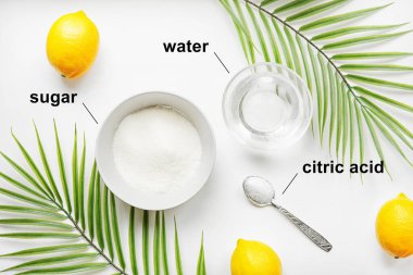 Evde saç aldırmak için nasıl şeker yapıştırıcı yapılır. Salgın sırasında güzellik salonuna bir alternatif. Şeker, su, sitrik asit gibi ev şekerleme malzemeleri. Düz beyaz bir masada yatıyordu..