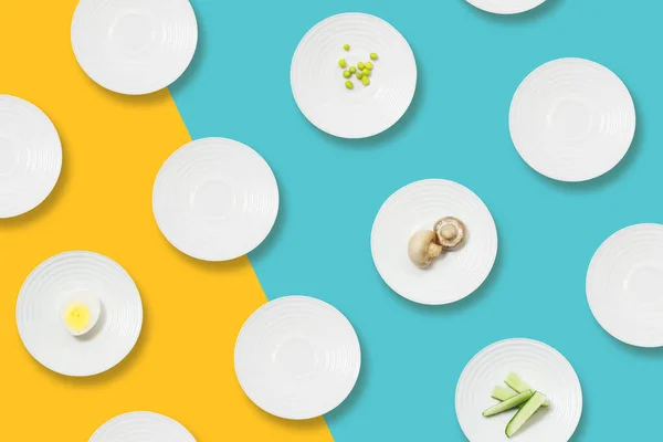 Sağlıklı beslenme minimalist kalıbı. Sarı-mavi arka planda diyet yemeği olan beyaz tabaklar. Kilo kaybı için diyet.
