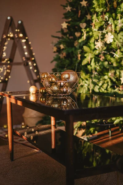 Kahve sehpasının üzerinde bir kasede altın toplar. Noel için hazırlık, iç dekorasyon.