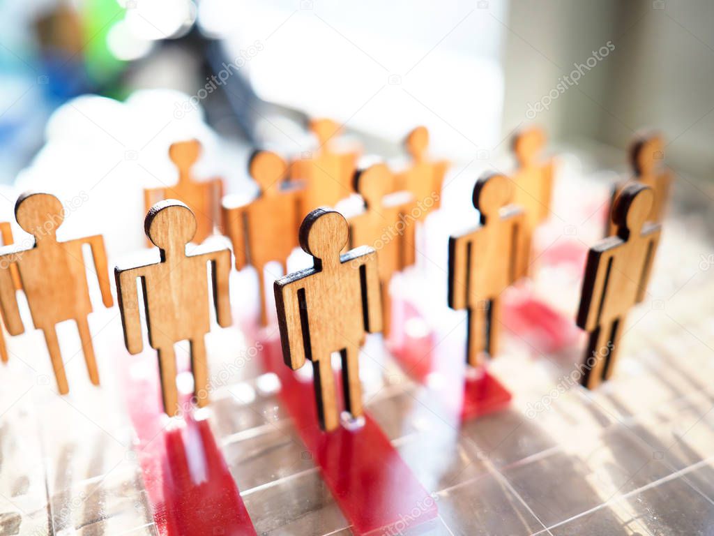 Little wooden toy people figures stand in row