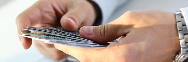 Чоловічі руки тримають і рахують купу кредитних карток — стокове фото