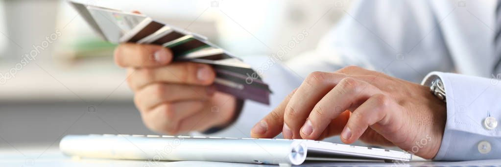 Male arms hold bunch of credit cards