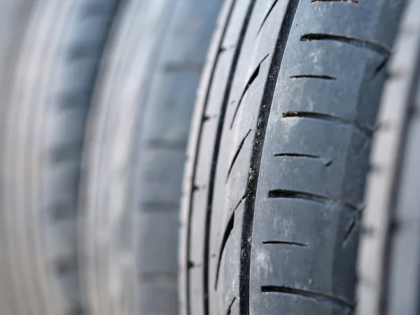 Set of used tyres stand in row at warehouse — Stock Photo, Image