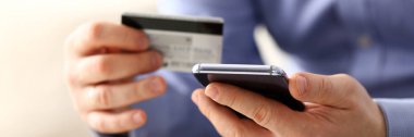 Kredi kartı ve telefon transfer yapmak takım elbiseli erkek silah tutun