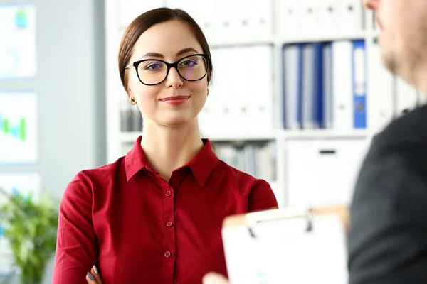 Menina sorridente bonita em blusa vermelha no local de trabalho olhar na câmera — Fotografia de Stock