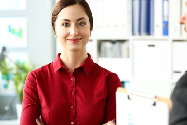 Menina sorridente bonita em blusa vermelha no local de trabalho olhar na câmera — Fotografia de Stock