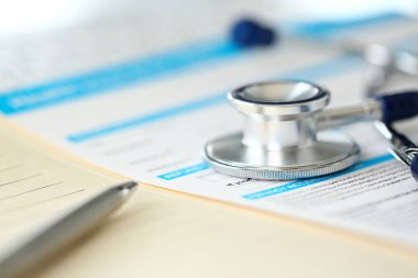 Stetoskop baş ve gümüş kalem tıbbi başvuru formunda yalan