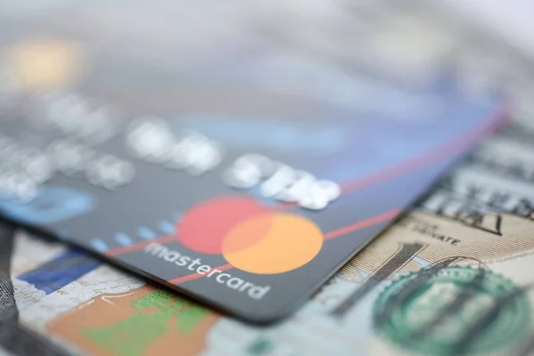 Reliëf afgestoken mastercard creditcard en honderd dollar biljetten closeup — Stockfoto