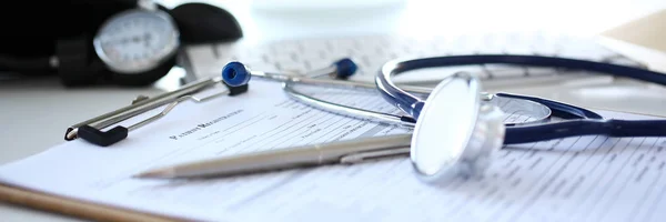 Stéthoscope tête et stylo argenté couché sur le formulaire de demande médicale — Photo