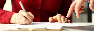 Gümüş kalem tutan kadın çalışanı belgelerde notlar yapma