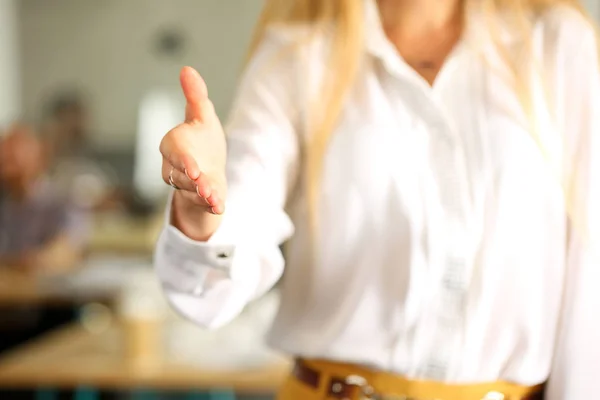 Female manager give hand as hello to client introducing herself