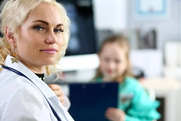 Reife blonde Arzt in ihrem Büro erhalten wenig Patient — Stockfoto