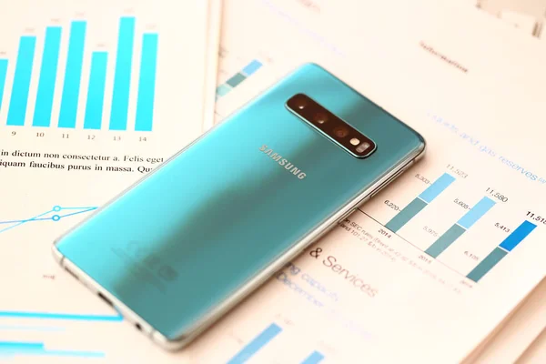 Samsung Galaxy S10 leżącego na różnych wykresów statystyk finansowych zbliżenie — Zdjęcie stockowe