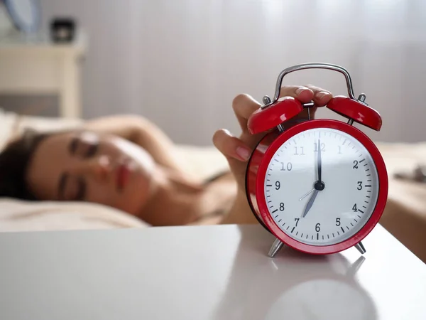 Mão feminina desligando alerta barulhento perturbador do despertador vermelho — Fotografia de Stock