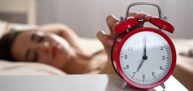 Kadın el Kırmızı çalar saatten rahatsız edici gürültülü uyarısı kapatma