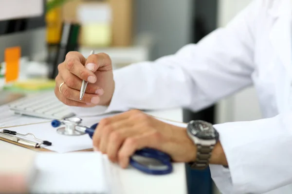 GP prescribing remedy sitting at working table — Stock Photo, Image