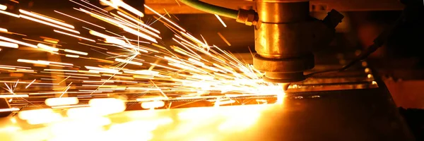 Bright blaze and sparkles while automated laser device cutting steel