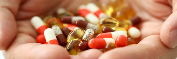 Man hold in arms set of different pills close-up