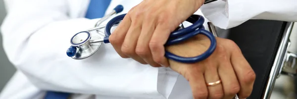 GP hands holding stethoscope and silver pen — Stock Photo, Image