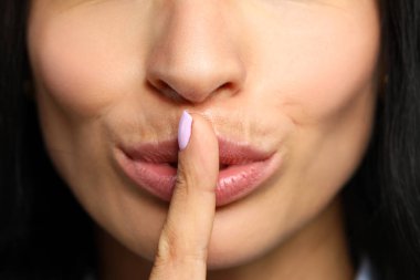 Güzel kadın kapalı kırmızı dudaklar parmağını koydu