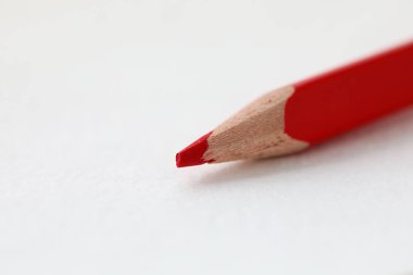 Kullanılmaya hazır beyaz kağıt parçasının üzerinde yatan kırmızı kalem